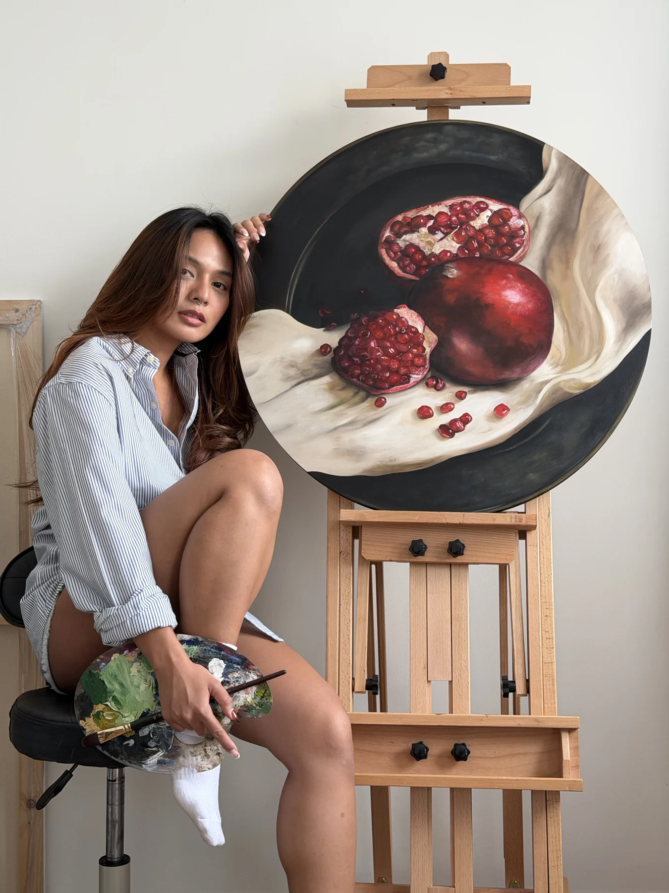 Mooky beside her painting Pomegranate in the studio